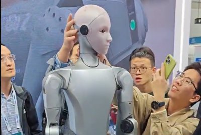 A Unitree H2 humanoid robotot közelről figyelik az IROS 2025-ön.